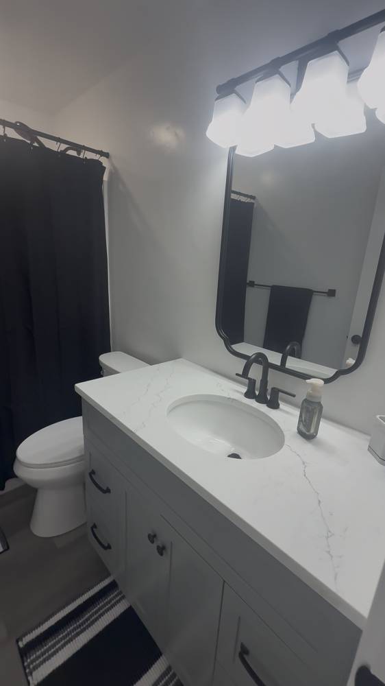 Finished bathroom vanity with quartz top and black fixtures