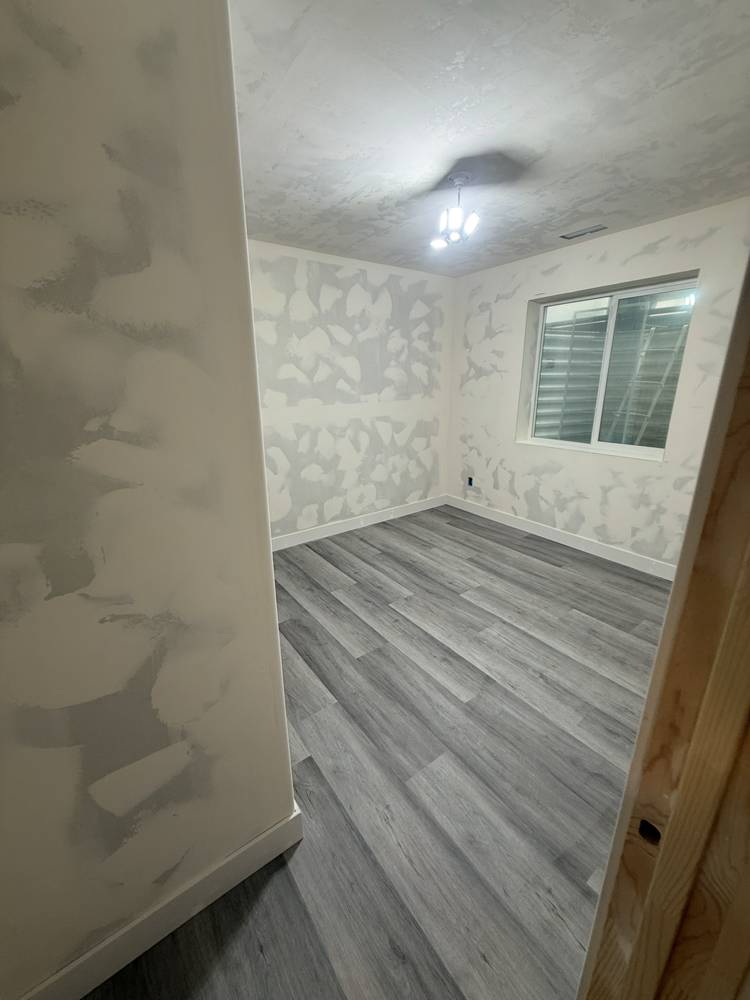 Bedroom with new vinyl plank flooring and drywall finishing